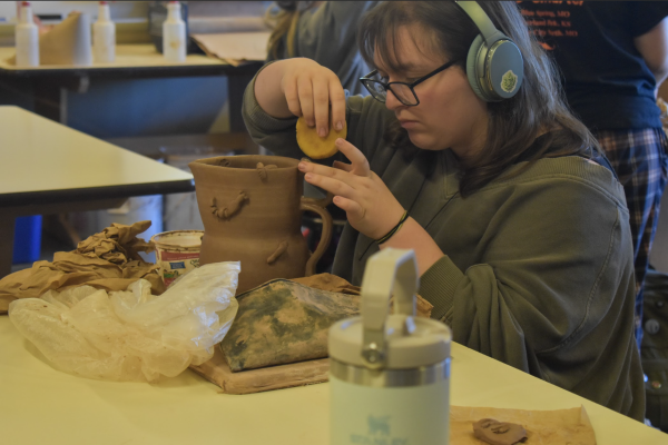 I work on my final project in ceramics. I worked on forming the handle for the bug pitcher. (Photo by E. Shetlar) 