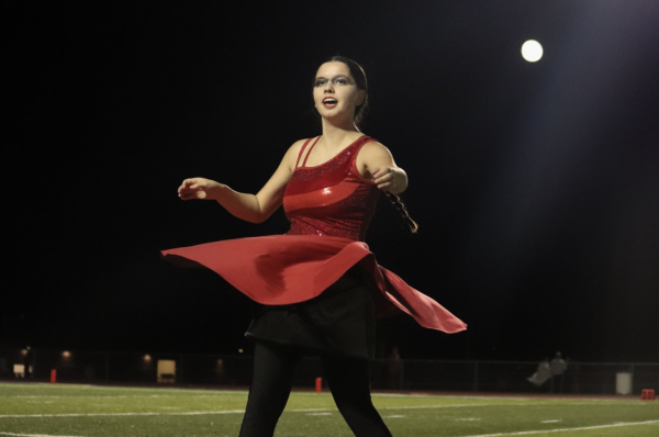 Taylor Malkames, 11, performs an outfit change during the halftime performance of the football game on Oct. 18. (Photo by M. Brown) 