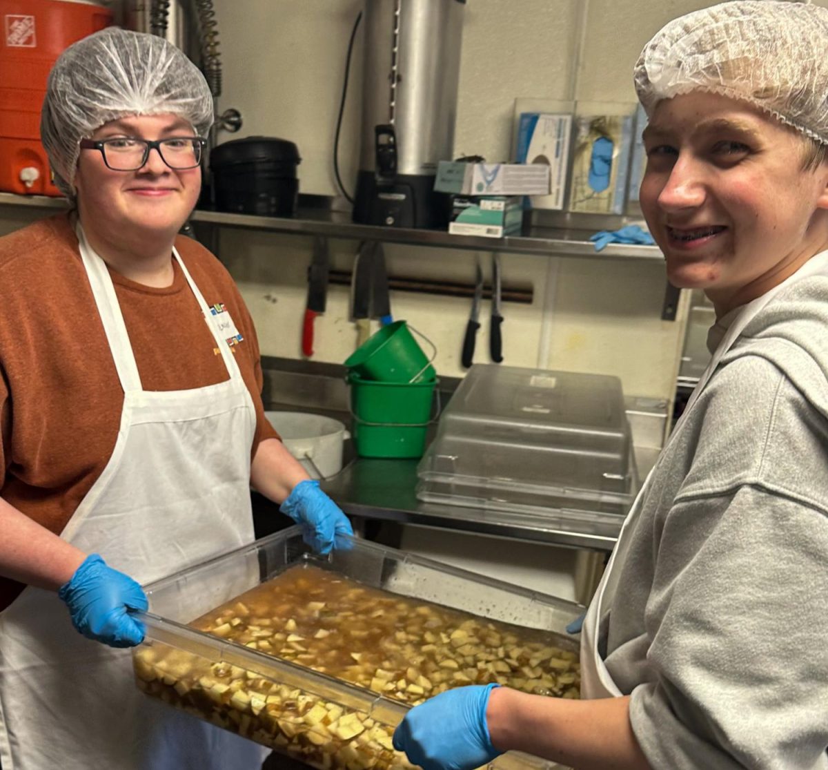 Daniel Heinen, member of the volunteer club, 11, and Spencer Boyd, 10, carry a tub of potatoes. (Photo by Kerri Rodden, provided by Daniel Heinen)