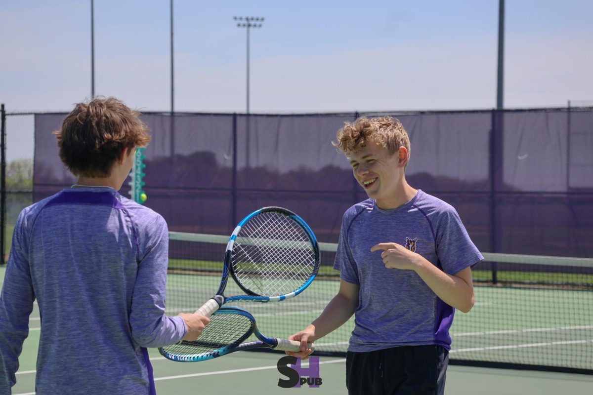 Maddoc Johnston, 11, and Finn Hogan, 12, talk in between sets during the varsity league tennis tournament April 29.