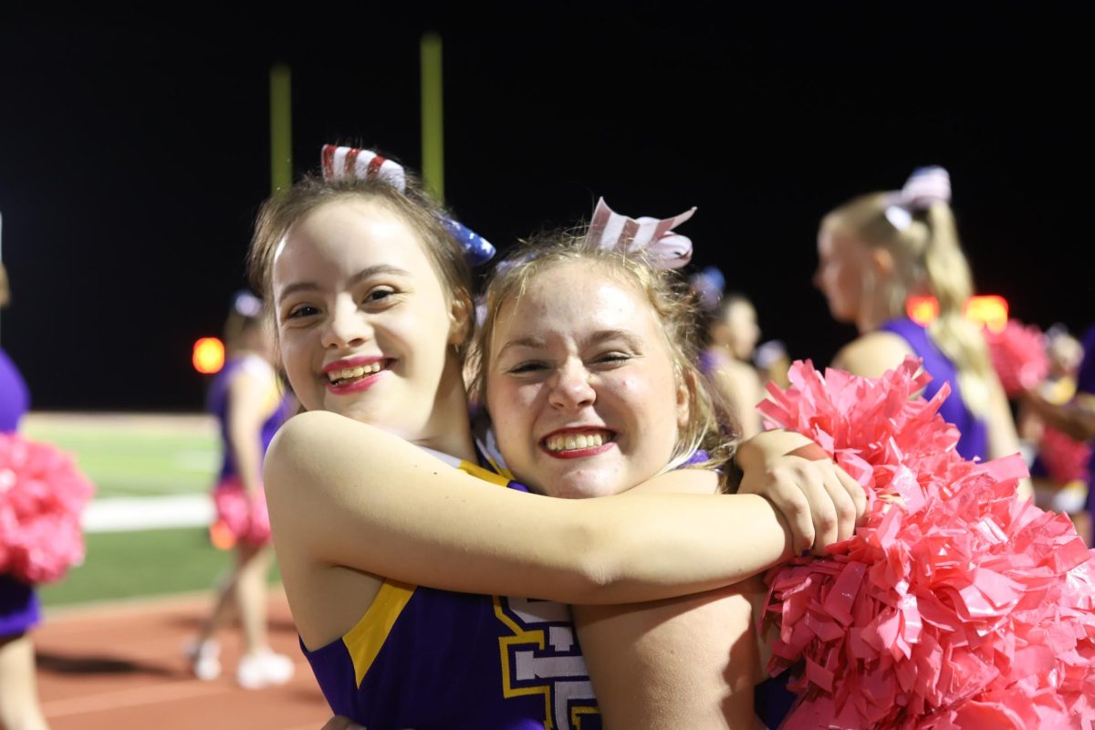 Rylee Jones, 12, and Willow Marcum, 10, give each other a big hug at a football game last season. Jones will be a captain this upcoming season.
