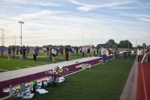 The marching band stands in attendance block at the beginning of rehearsal. Organized attendance has been necessary recently as the band has grown larger.