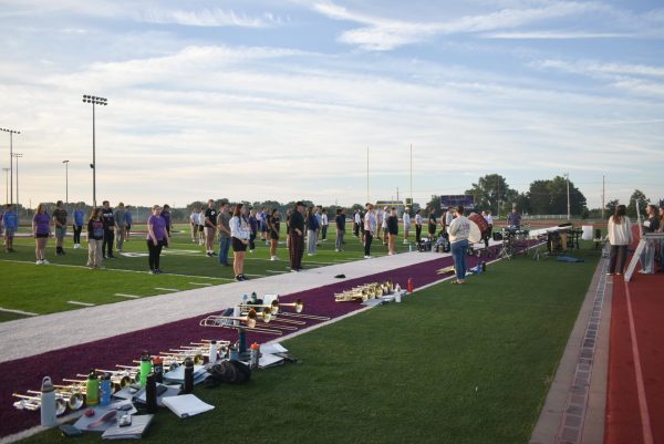 The marching band stands in attendance block at the beginning of rehearsal. Organized attendance has been necessary recently as the band has grown larger.