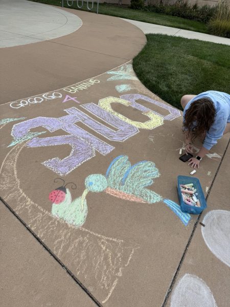 Zoe Tarvin, 11, sketches with sidewalk chalk to represent StuCo at the Chalk the Walk event held Wednesday, Sept. 10. This is one of many traditions leading up to homecoming day.