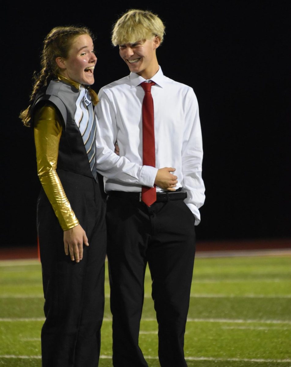 Meek and O’Shea laugh as they stand together on the football field during halftime. They both shared that they were surprised when their names were announced. 