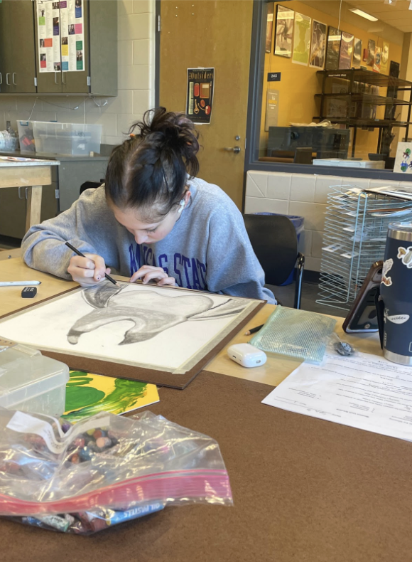 Beauchamp works on an art piece. Their sketching process allows them to combine precision and creativity.