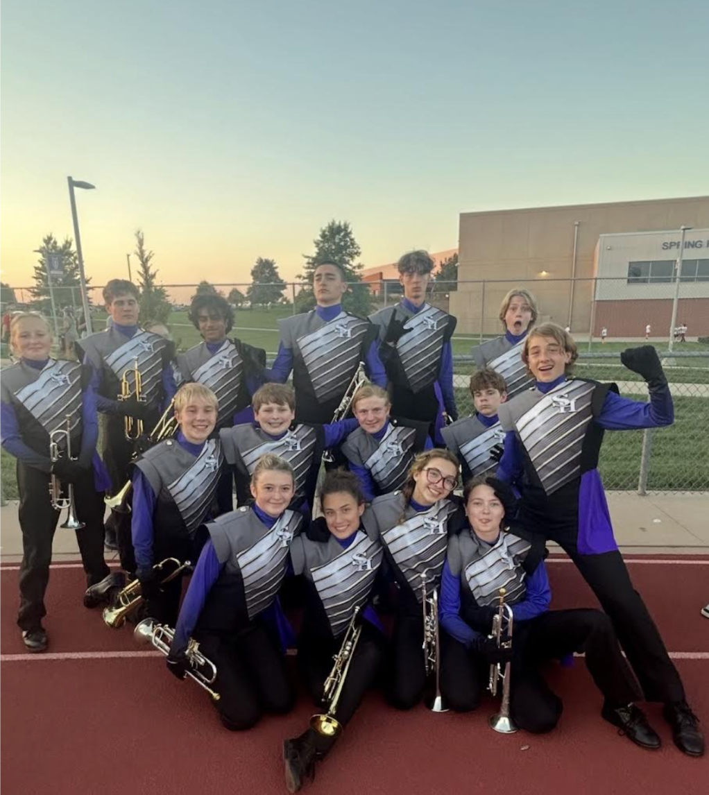 Ostermann poses with the trumpet section for a group photo at a football game. Students in music programs often form strong friendships and connections through activities like this.