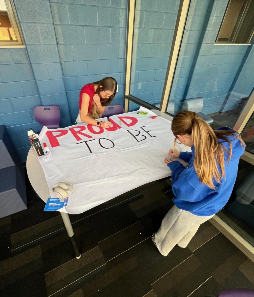 Addison Lightcap and Susan Plowman, 12, help make a poster that students can sign at lunch, pledging to be drug free.