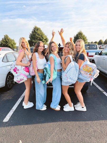 Chloe Young, 12, and their friends show off their senior backpacks on the first day of school. Simple senior traditions like this add bits of fun throughout the year.
