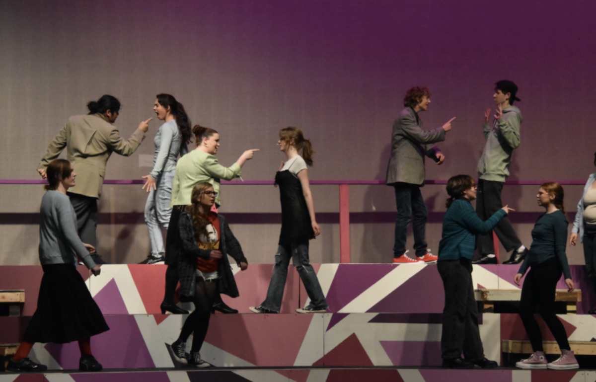 Multiple cast members point sharply at one another during a tense confrontation in Freaky Friday. This scene highlights the comedic conflict that drives the story and showcases the cast’s ability to deliver dramatic moments with energy.