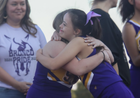 Rylee Jones, 12, embraces Willow Marcum, 10, on their senior night for cheer. Jones and Marcum met through the proximity of unified classes and sports.