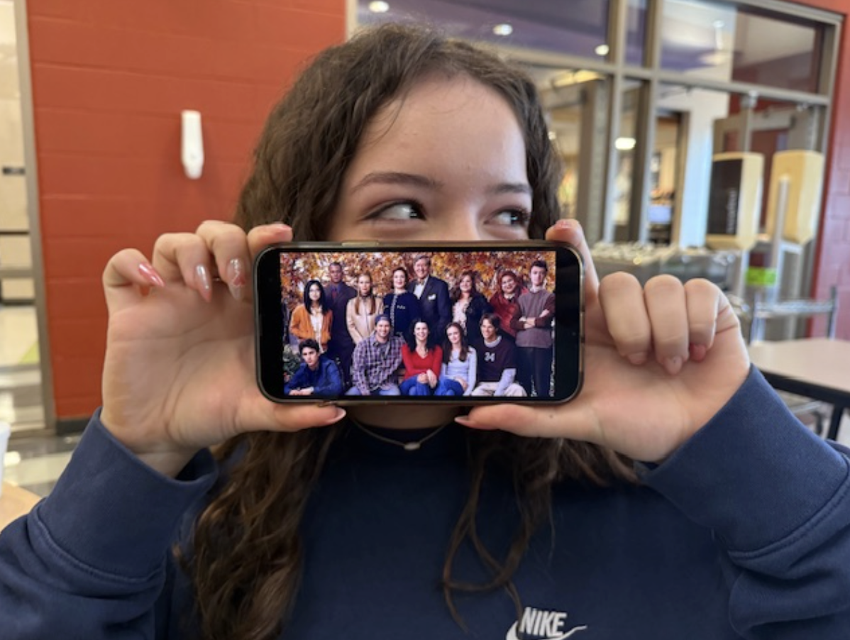 Paighton Geiter, 10, poses with a picture of the cast of Gilmore Girls, one of their favorite shows. They shared memories with their mom over this show, so it had a strong importance to them.