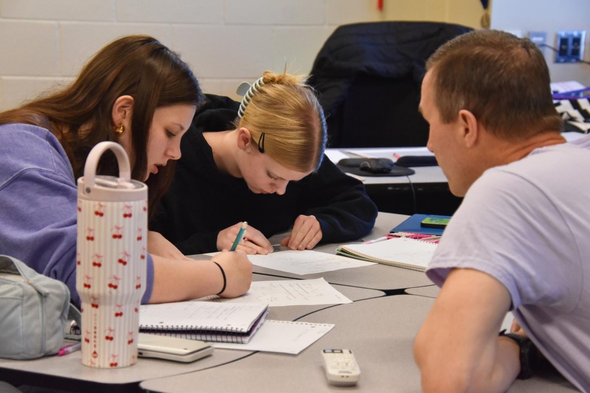 Brent Smitheran, math teacher, helps McKenzie Riffle and Elizabeth Olson, 11, with their trig assignments on Feb 27. 