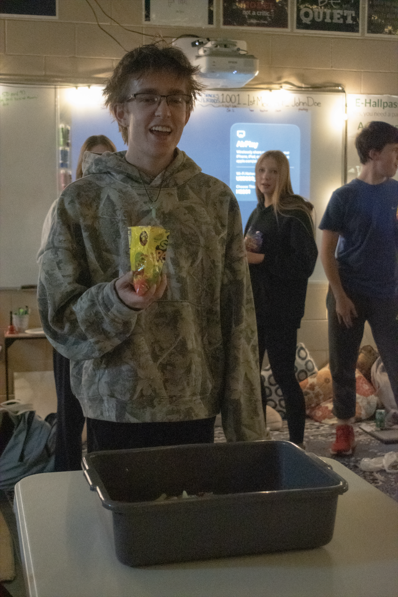 Dylan Estes, 12, holds sour patch kids to dump them into a candy salad during a SPUB work night on Feb. 23.
