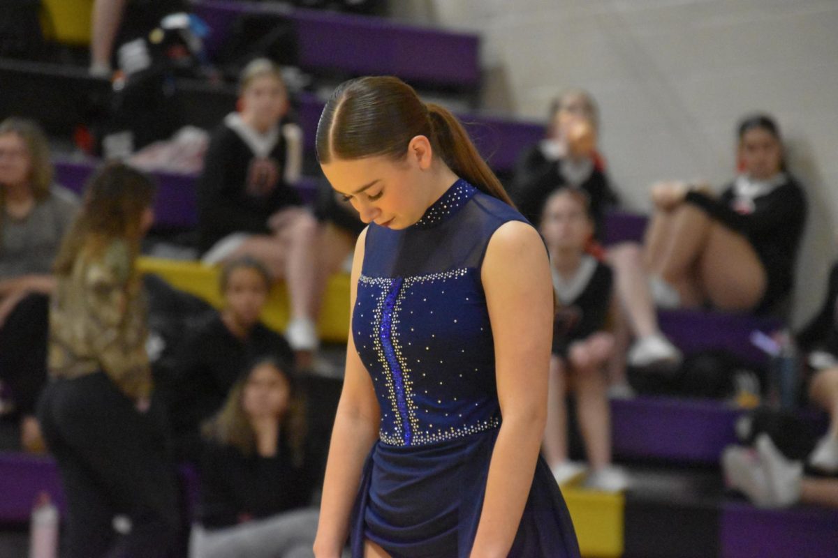 Preparing to embrace the music, Shayla McKay, 12, lets the lights set the mood. At their solo showcase, they had put their all into showing the audience their skill and the time put into their dance. 