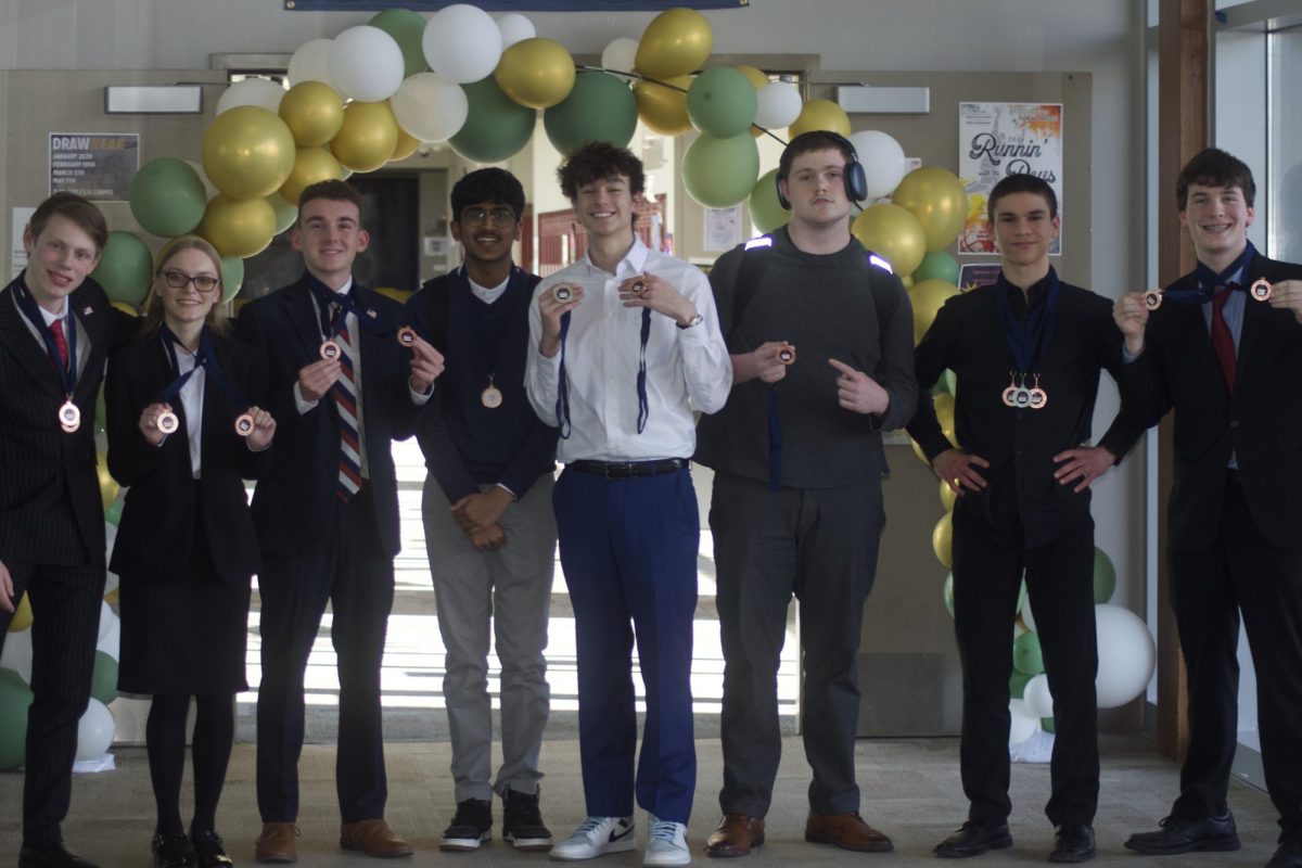 Several forensics members pose or hold medals on March 7 after a tournament at Saint James Academy. 
