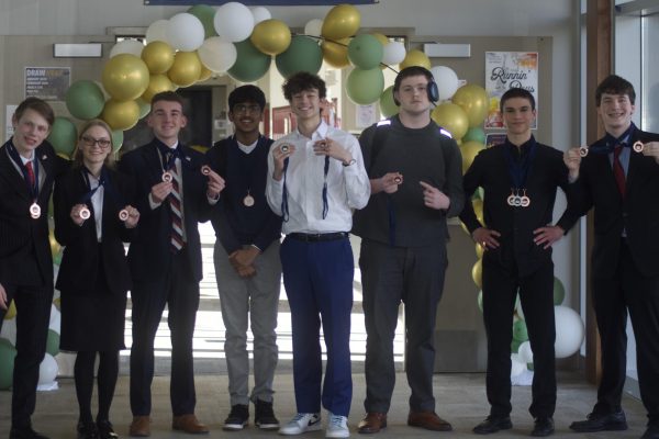 Several forensics members pose or hold medals on March 7 after a tournament at Saint James Academy. 