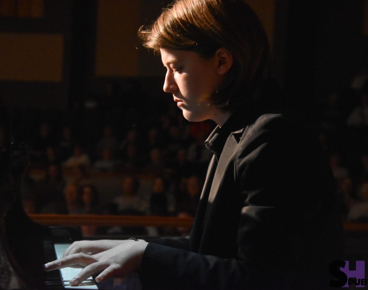 On March 9, Audrey Schoening, 12, plays a piano solo during the combined choir, band, and orchestra concert.
