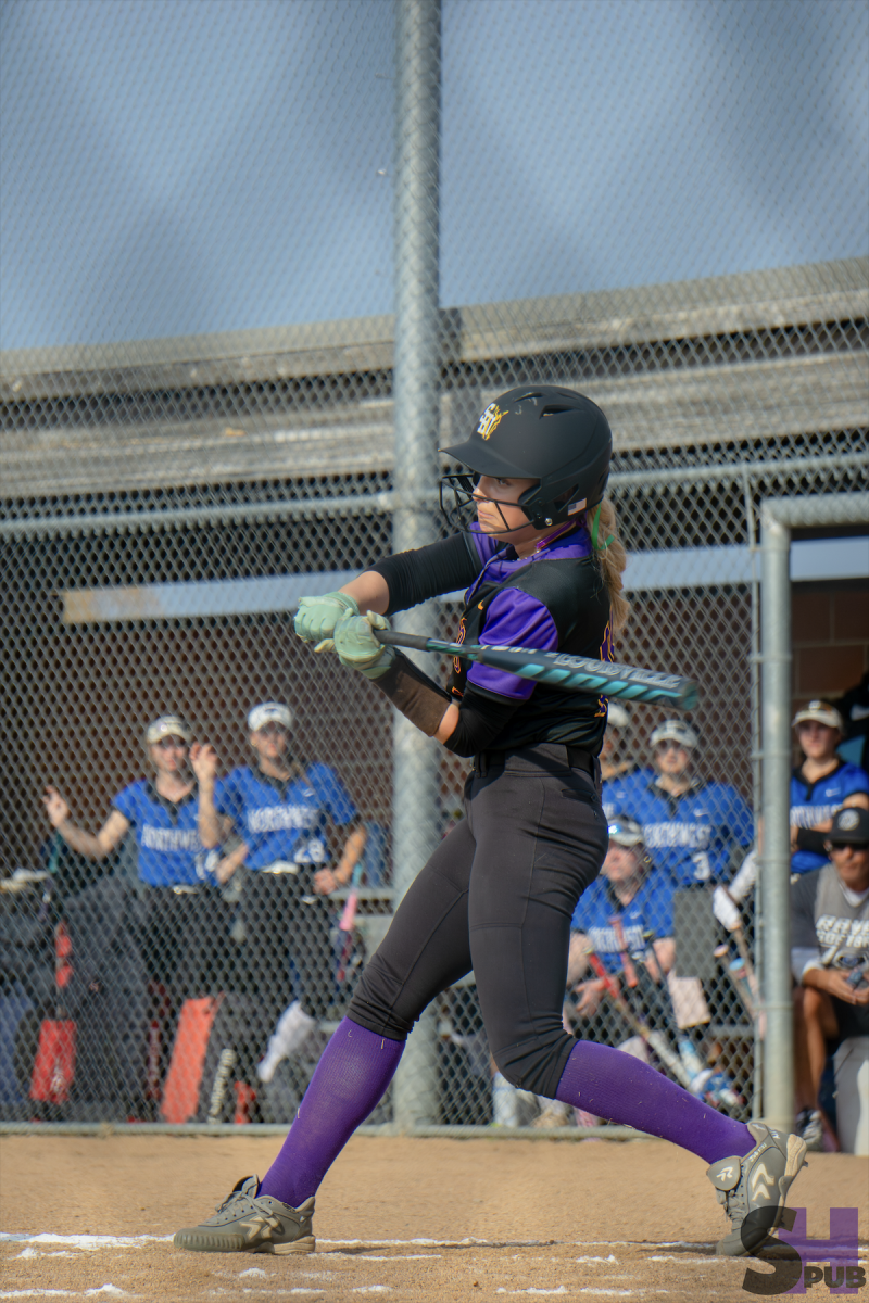 Lynnlee Vaughan, 9, prepares to hit the ball in a varsity softball game against Olathe Northwest on March 24.