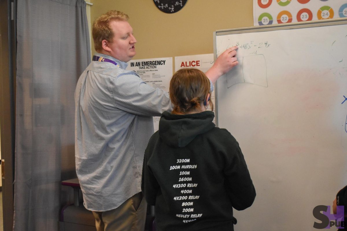 On April 2, Luke Zuroske, math teacher, shows Jerah Mills, 9, how to solve an equation in algebra I. 