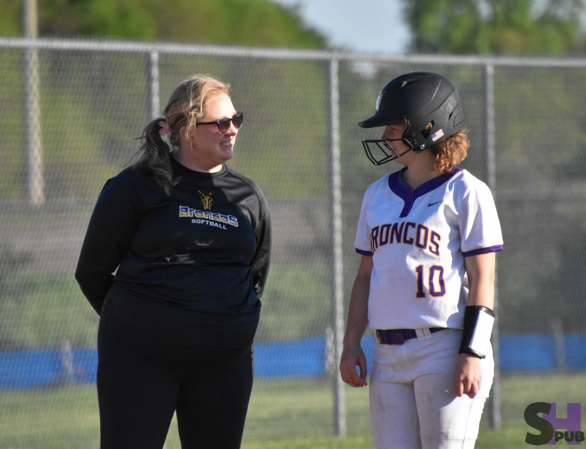 During a home game against Saint Thomas Aquinas on April 20, Hailey Bachura, JV softball coach, encourages Leslie Howell, 10. 
